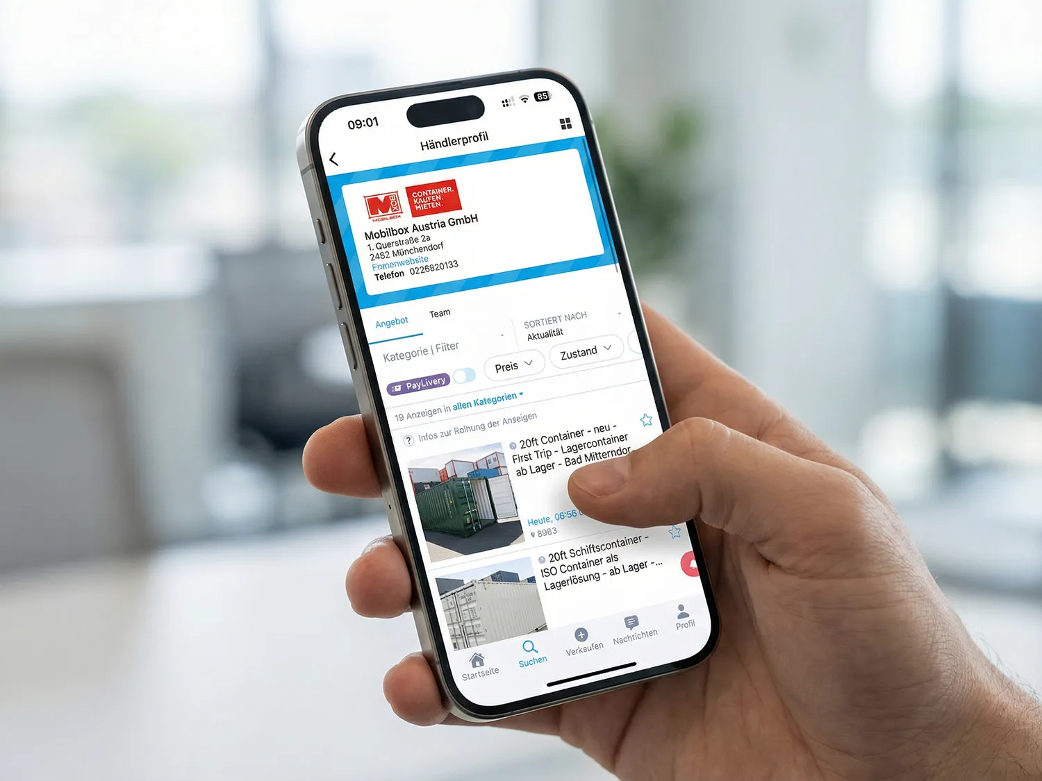 Person hält ein Smartphone mit geöffneter Willhaben-App und zeigt den Mobilbox-Shop für gebrauchte Container kaufen.